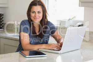 Woman using the laptop in the kitchen