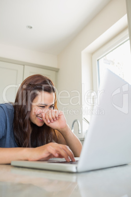 Woman typing on laptop while laughing