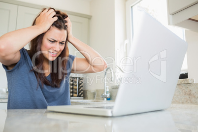 Woman getting angry while using laptop