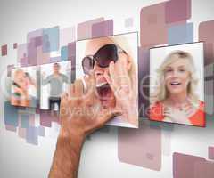 Male hand selecting one photo from digital wall