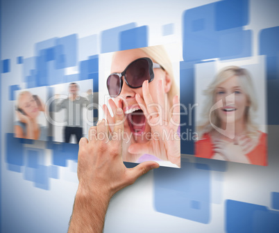 Male hand selecting picture from digital wall