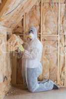 Worker filling walls with insulation