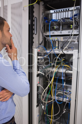Thoughtful man looking at servers