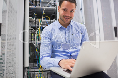 Happy man using laptop to check servers