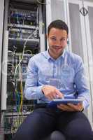 Technician working on tablet pc beside servers