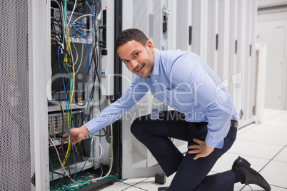 Technician plugging cable into server