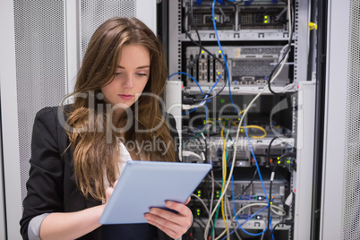Woman using tablet pc in front of servers