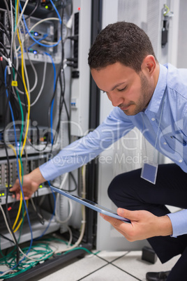 Man using tablet pc to work on servers