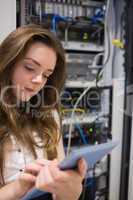 Woman working on servers checking tablet pc