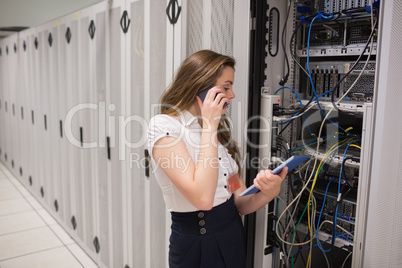 Woman on the phone holding tablet pc checking the servers