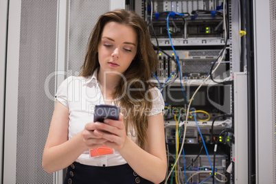 Woman texting in front of servers
