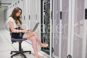 Woman working on servers with laptop
