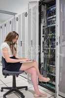 Woman working on laptop with servers