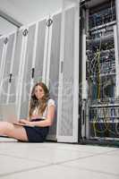 Smiling woman working with servers on laptop