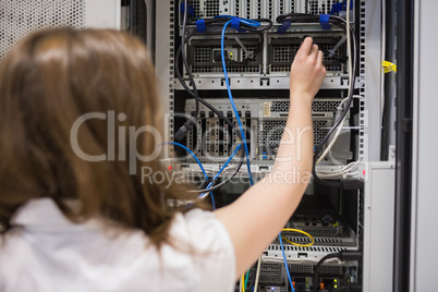 Woman fixing wires of servers