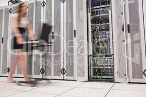 Woman pushing computer through data center