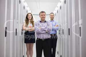 Three smiling technicians standing in data center