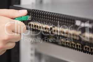 Woman plugging USB cable into server