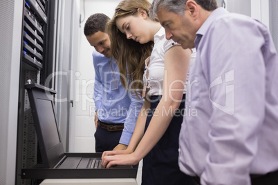 Three technicians looking at laptop