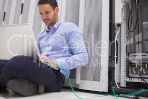 Man concentrating on laptop connected to server
