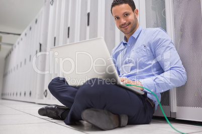 Man working on laptop connected to server