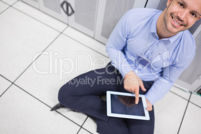Technician happily using tablet pc in data center
