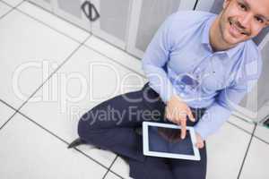 Technician happily using tablet pc in data center