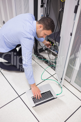 Technician connecting his laptop to server