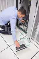 Technician connecting his laptop to server