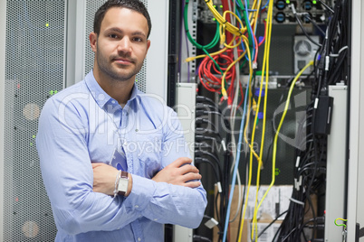Man standing with arms crossed in data center
