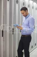 Technician doing maintenance with tablet pc in data center