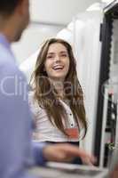 Woman working on servers laughing with colleauge