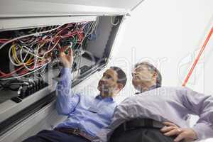 Technicians checking wires of server