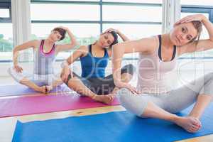 Women sitting and stretching at yoga class