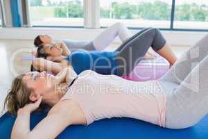 Women doing sit ups on exercise mats