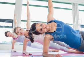Women in side plank yoga pose
