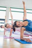 Smiling women in side plank yoga pose