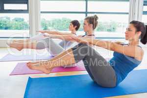 Women at yoga class in boat pose