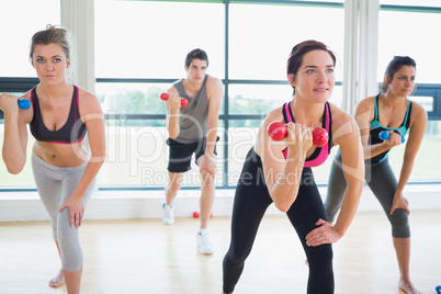 People lifting weights in aerobics class