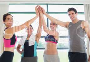 Smiling people high fiving each other in gym