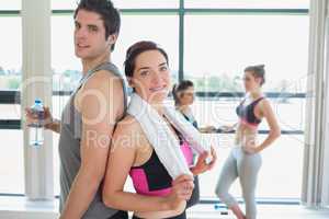 Man and woman standing back to back at the gym