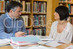 Man and woman talking in library
