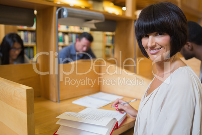 Black-haired woman reading a book in library