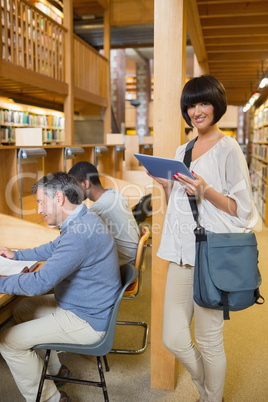 Woman with tablet pc in library