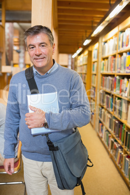 Man standing next to shelves in a library
