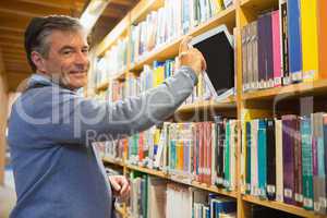 Man pulling out a tablet pc from shelves