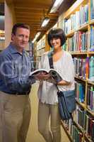 Happy man and woman standing in library