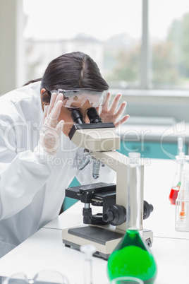 Woman looking through microscope