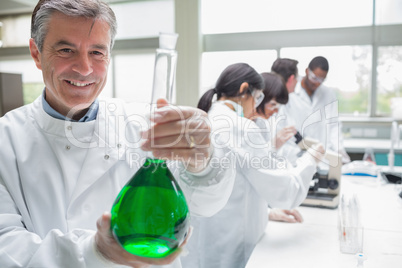 Chemist smiling and holding beaker