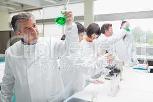 Chemists doing research on green liquid